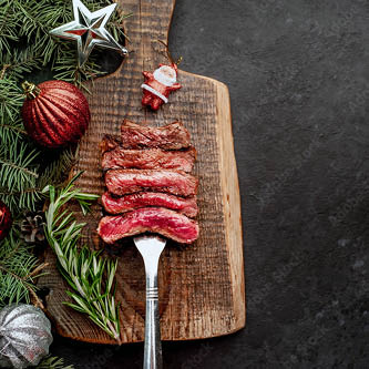 Pepperell's Fresh British Beef Ribeye Steak on a wooden platter with christmas baubles Pepperell's Fresh British Beef Ribeye Steak on a wooden platter with christmas baubles